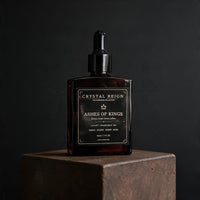 Ashes of Kings fragrance oil bottle on dark stone pedestal